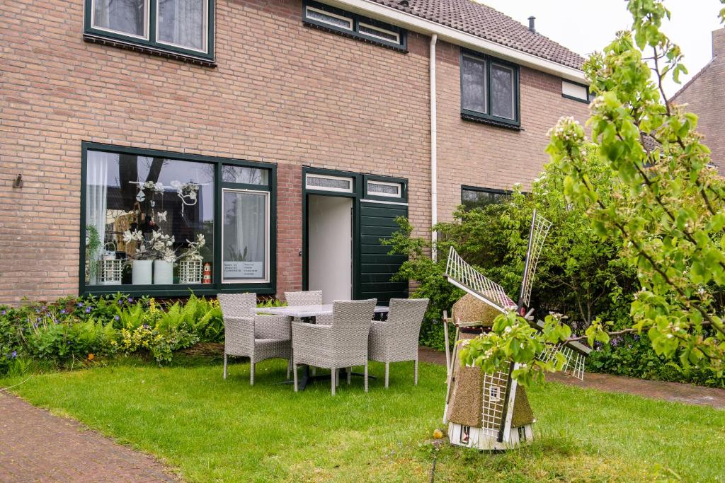 a patio with chairs and a table in front of a house at B&B Molenaar in Buren