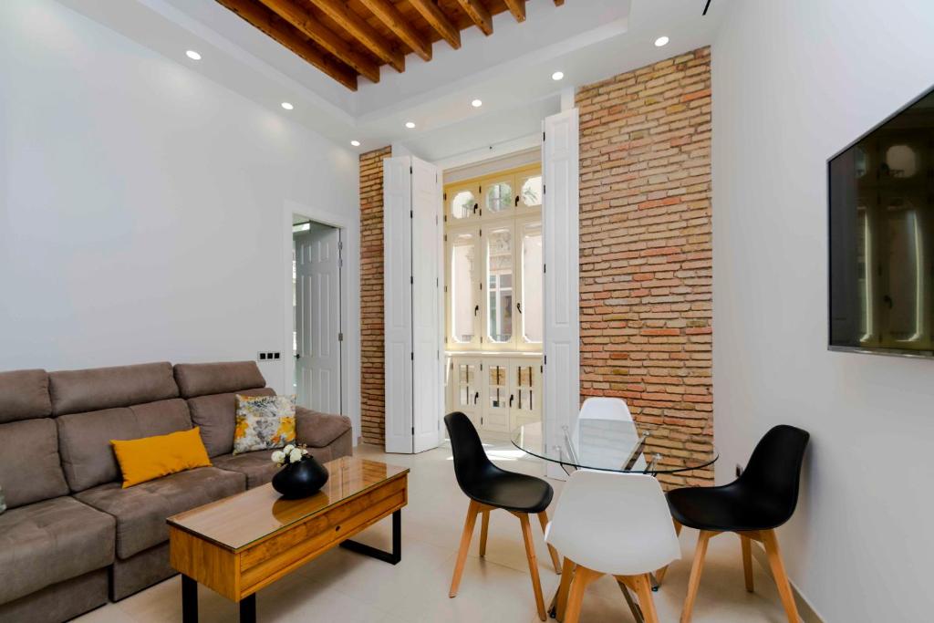 a living room with a couch and chairs and a table at INMálaga Santos Suites 1 in Málaga