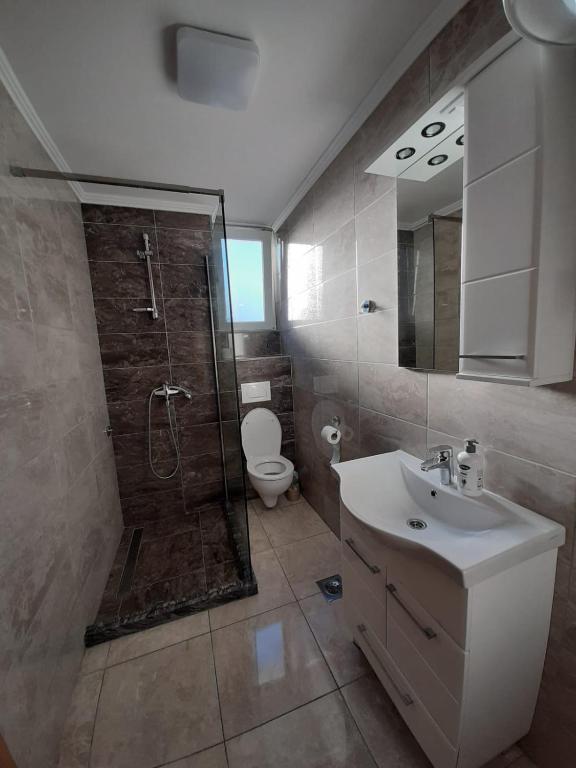 a bathroom with a shower and a sink and a toilet at Apartmani Pantovic - Apartman 1 in Trebinje