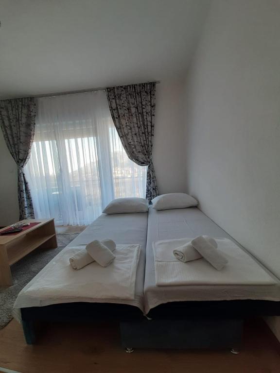 a bedroom with a large bed with two pillows at Apartmani Pantovic - Apartman 1 in Trebinje