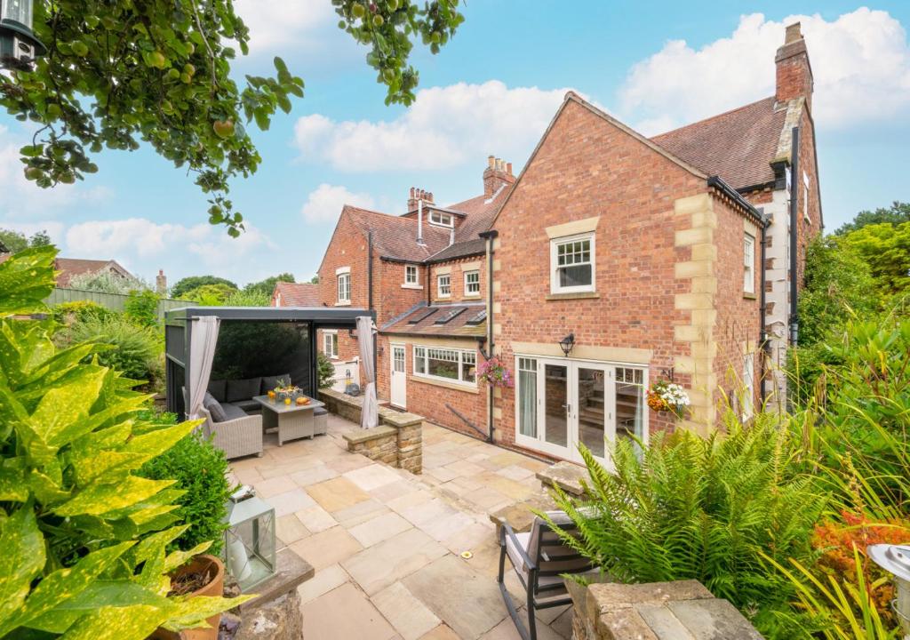 an exterior view of a brick house with a patio at Church Beck Retreat in Scalby