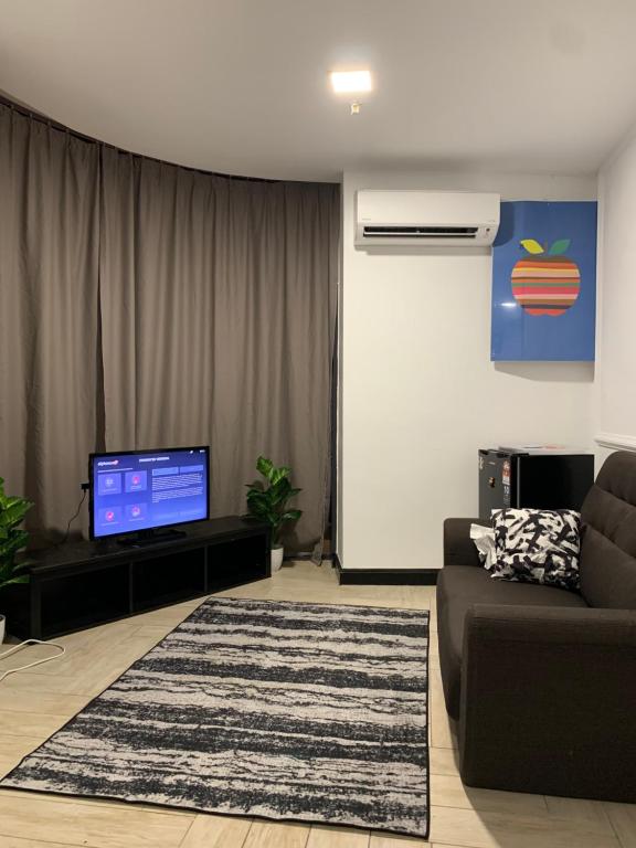 ein Wohnzimmer mit einem Sofa und einem Flachbild-TV in der Unterkunft AmicaHomes Studio 3 Empire City Free wifi & Netflix in Petaling Jaya