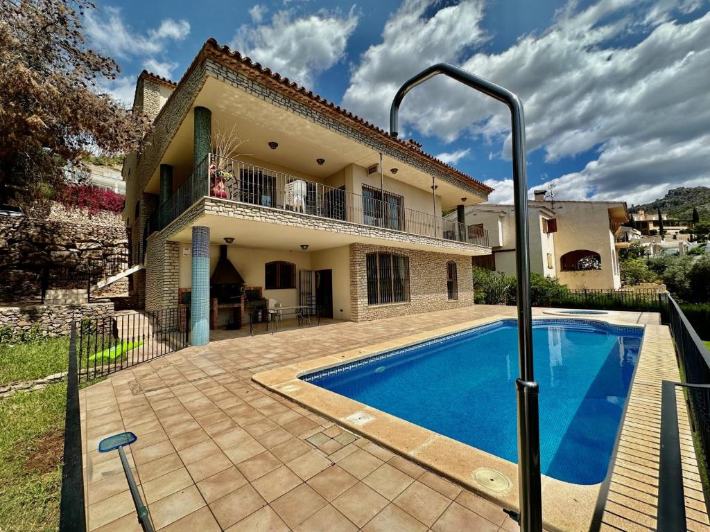 a villa with a swimming pool in front of a house at Villa la Parreta REF.025 in Benicàssim