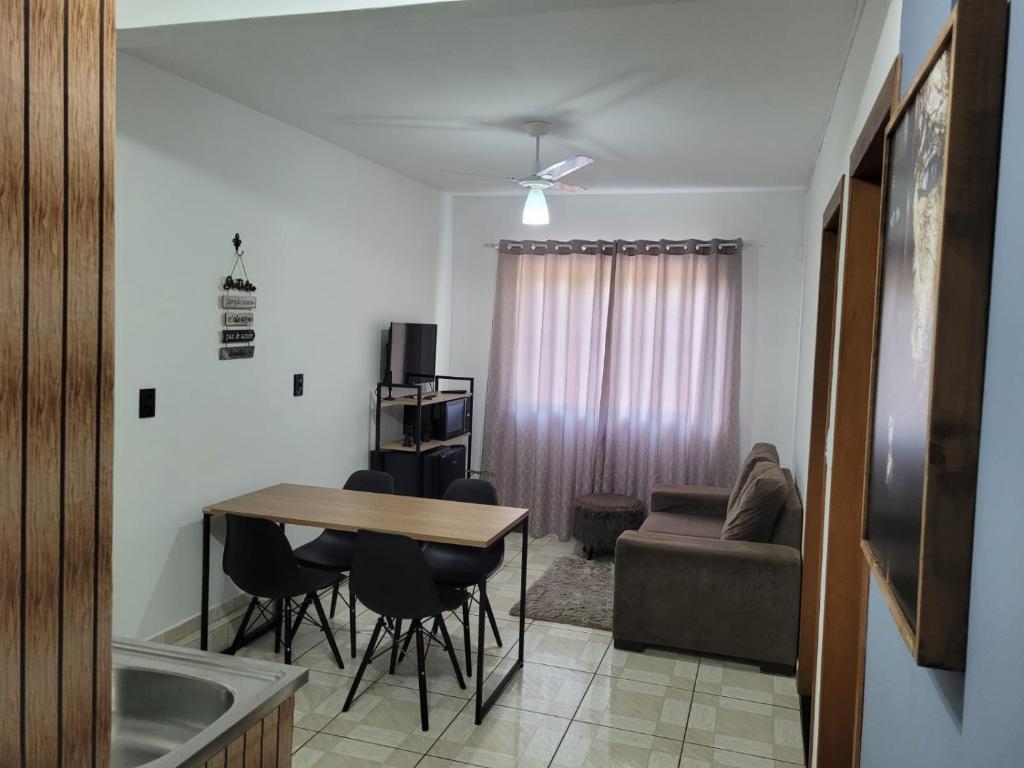 a kitchen and living room with a table and a couch at Apartamento Aconchego Azul Pomerode in Pomerode