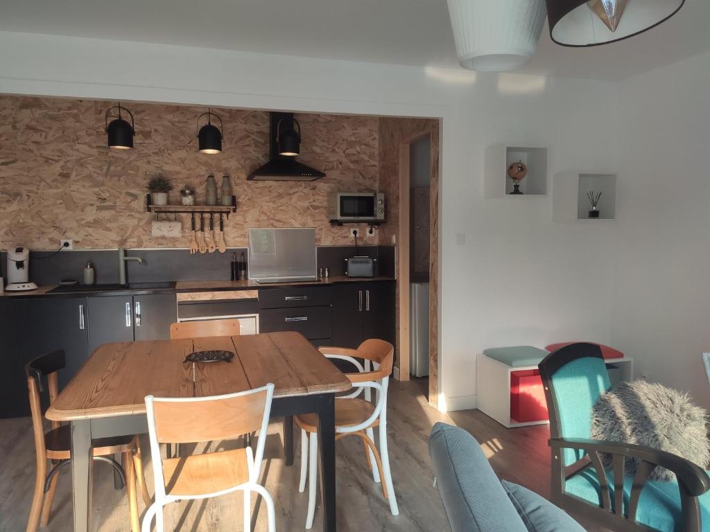 una cucina e una sala da pranzo con tavolo e sedie in legno di Maison La Coulonnaise a Coulon