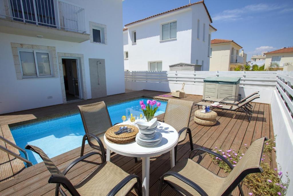 un patio con mesa y sillas en una terraza en Villa Daffodil, en Protaras