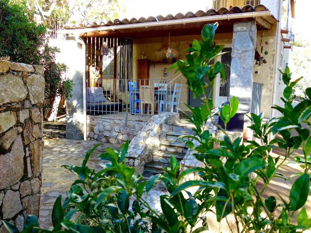 ein Haus mit einer Veranda mit blauen Stühlen davor in der Unterkunft A ChiOsella Égée in Corbara