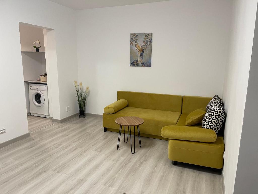 ブカレストにあるTriumf Apartmentのリビングルーム(緑のソファ、テーブル付)