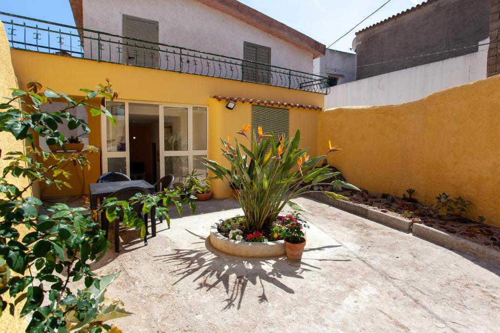 a courtyard of a yellow house with a plant at Appartamento Irgoli - Sardegna in Irgoli