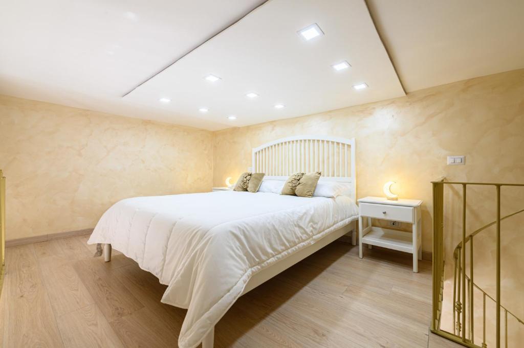 a bedroom with a large white bed in a room at La magnifica napoli apartments gold house in Naples