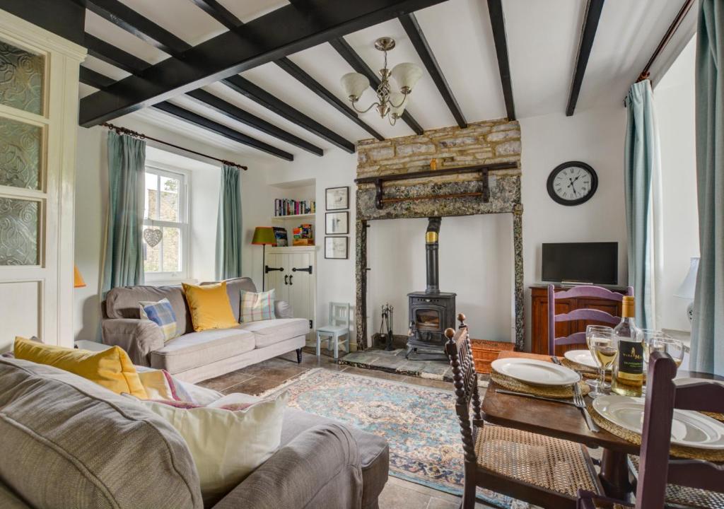 a living room with a couch and a fireplace at Calverts Nook in Hawes