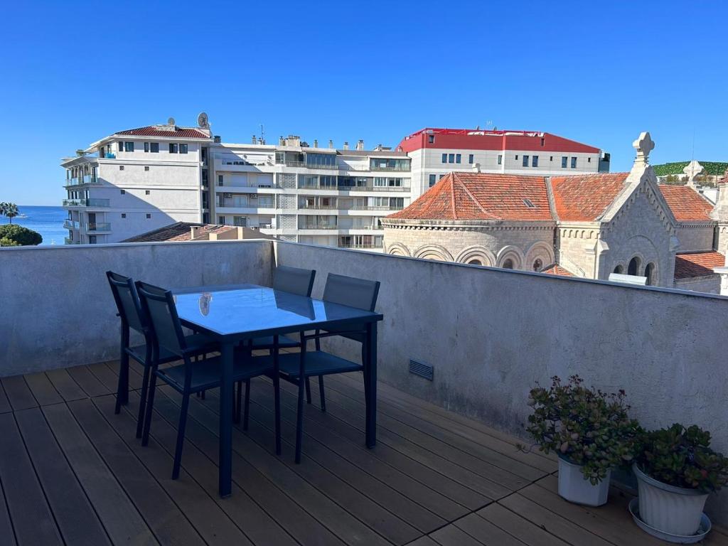 einen Tisch und Stühle auf einem Balkon mit Gebäuden in der Unterkunft Petit Paris - Incantevole appartamento in centro a Cannes a pochi passi dal Palais de Festival in Cannes