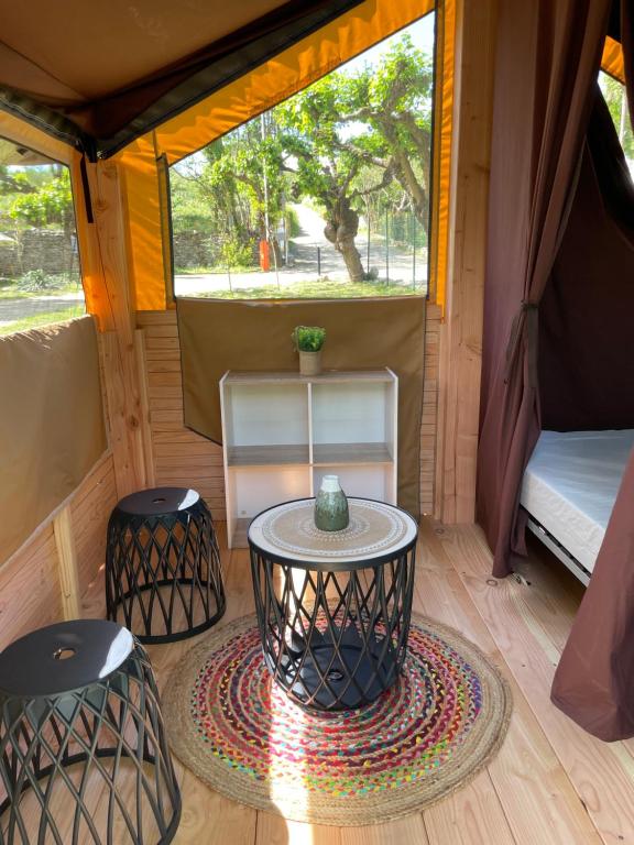 Chauzon的住宿－Camping Beaussement Baroudeur，帐篷内的房间,配有桌子和两张凳子
