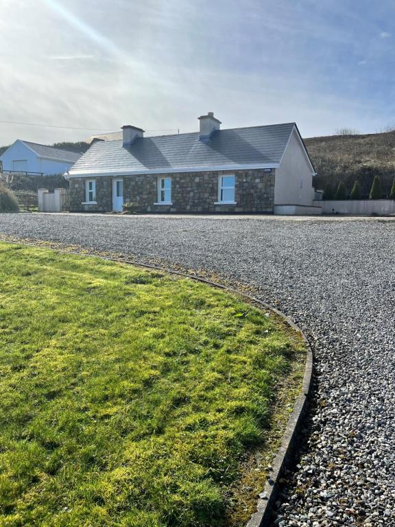 a house on the side of a gravel road at Bridie's Place in Ballycastle