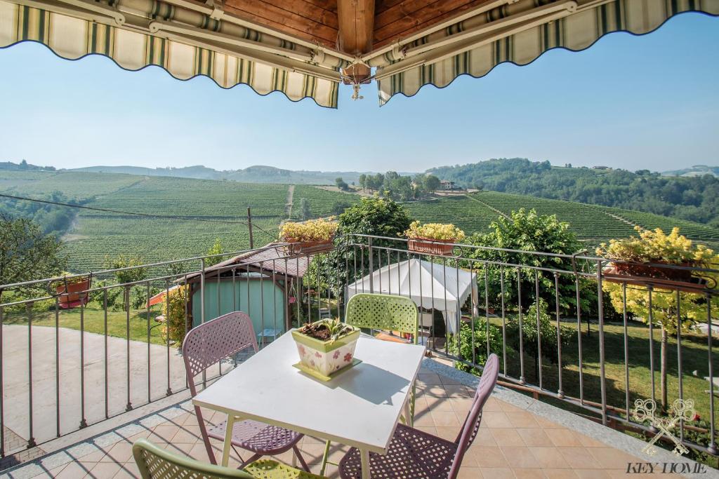 een patio met een tafel en stoelen op een balkon bij SUNNY HOUSE in Diano dʼAlba