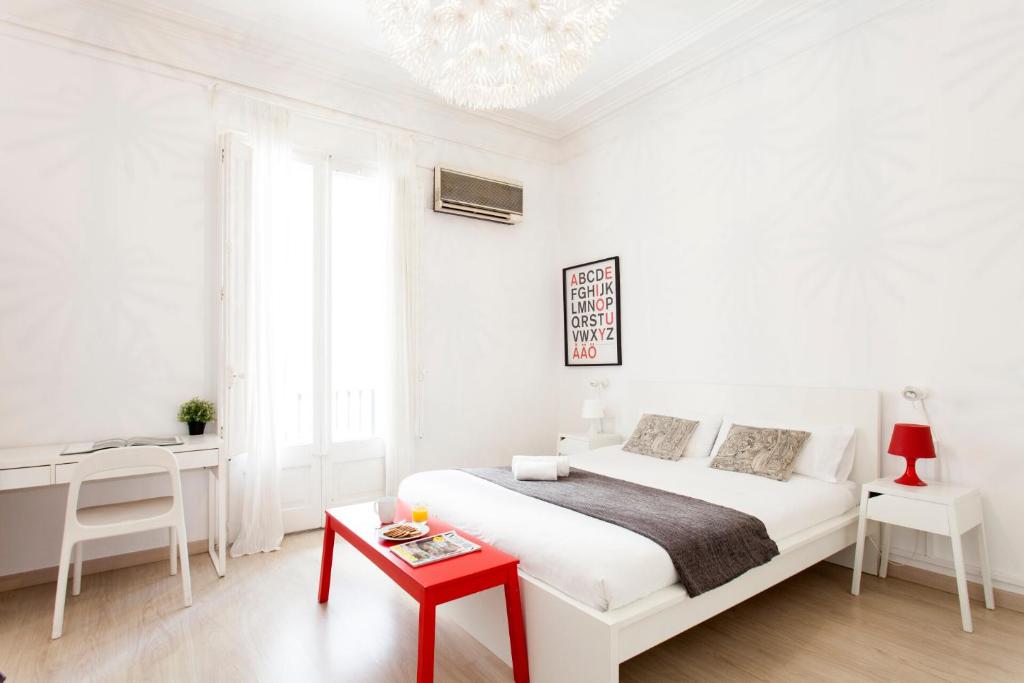 een witte slaapkamer met een wit bed en een rode tafel bij AB Passeig de Gràcia Pelai in Barcelona