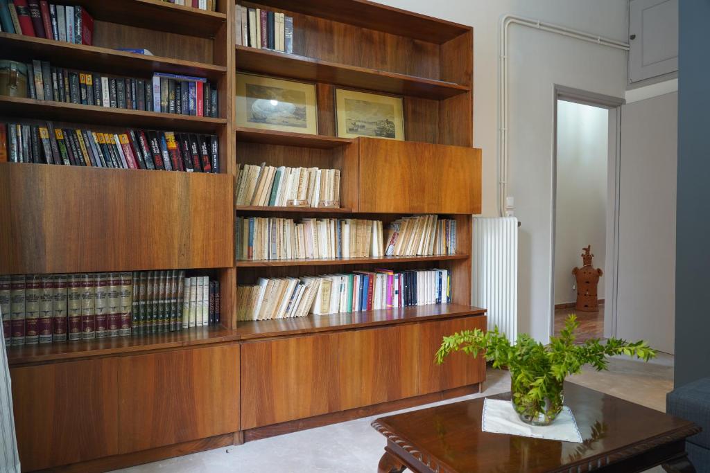 biblioteka z drewnianymi półkami na książki wypełnionymi książkami w obiekcie MARIALINA NAFPLIO w Nauplionie