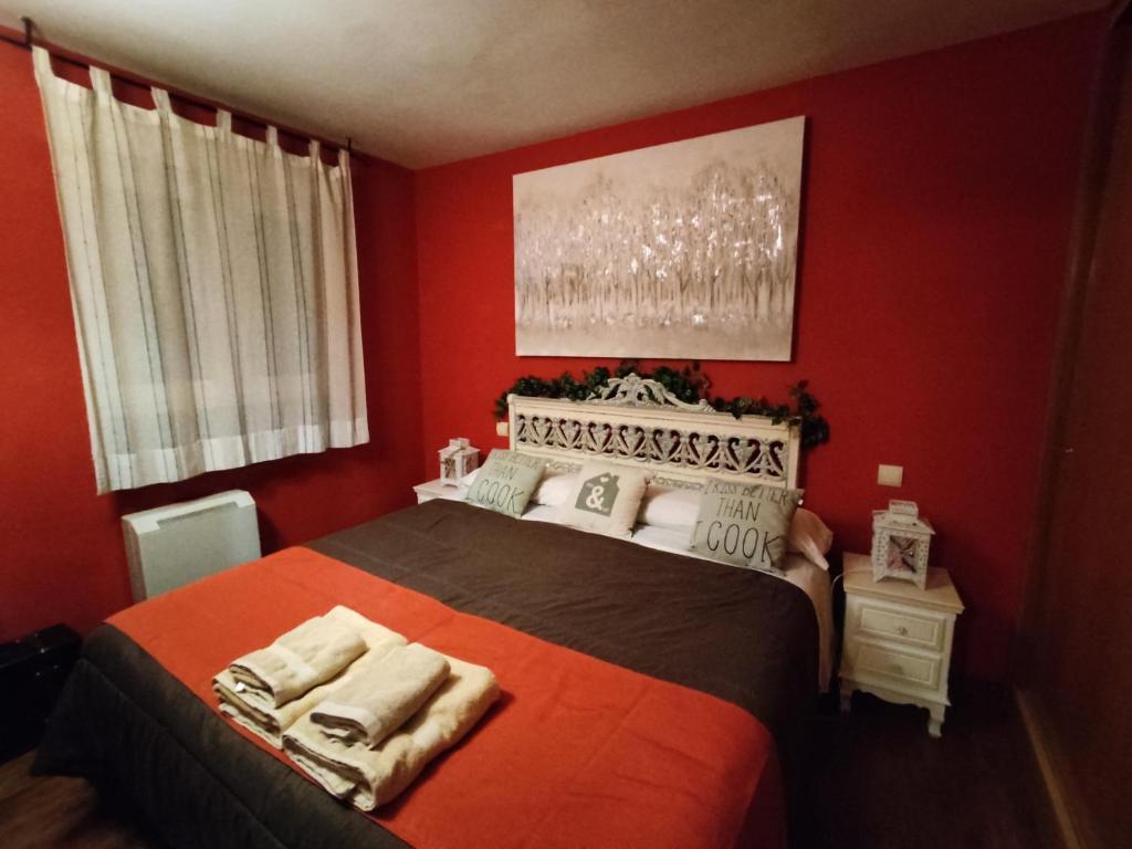 1 dormitorio rojo con 1 cama grande en una habitación en Apartahotel Rural CollaRubio Luxury en Collado Mediano
