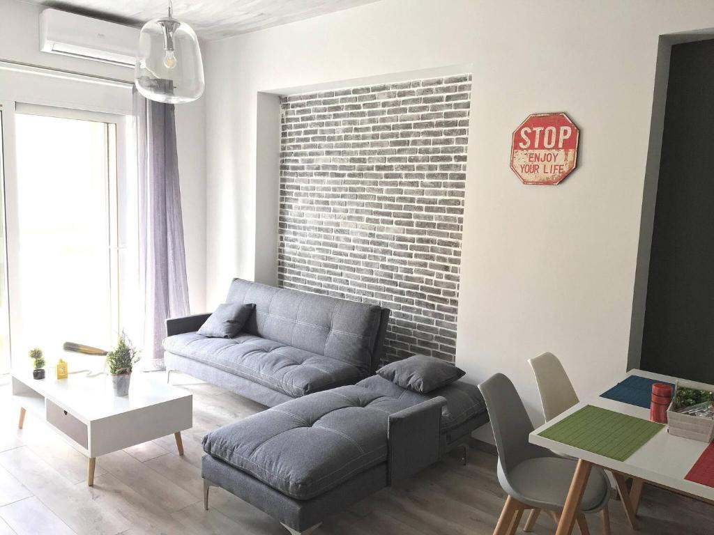 a living room with a couch and a stop sign on a brick wall at Pegasus Amazing Flat, 15min Walk To The Beach in Chania Town