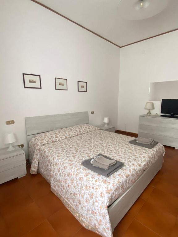 Habitación blanca con cama y TV en G&G Apartment, en Nápoles