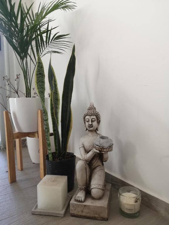 una estatua de un buddha sentado en una mesa con plantas en Valen House en Malargüe