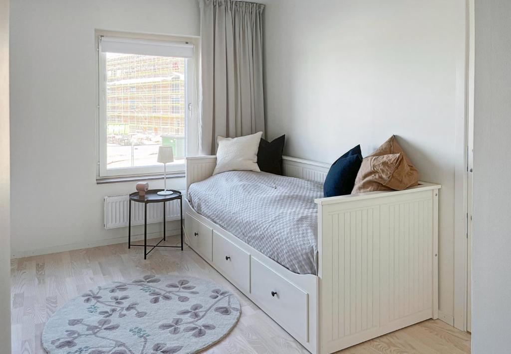um quarto branco com uma cama e uma janela em Hyllie Appartement - New Construction em Malmo