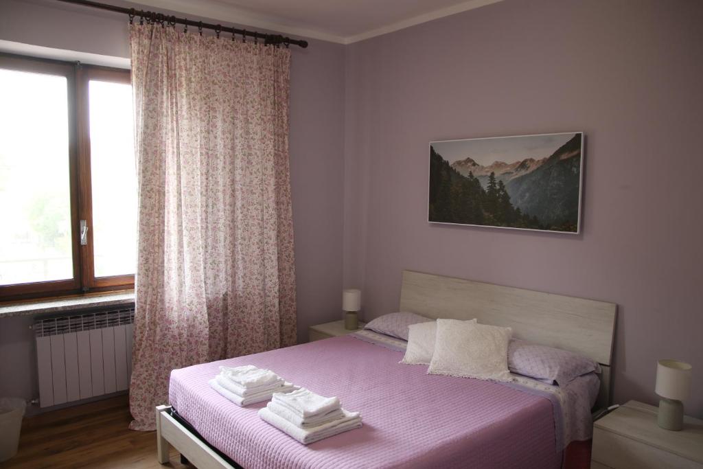1 dormitorio con cama rosa y ventana en Bed And Breakfast Del Lago, en Avigliana