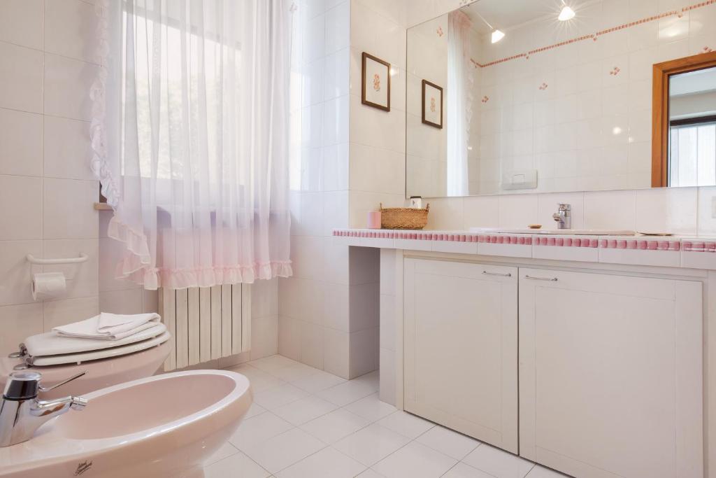 łazienka z umywalką, toaletą i lustrem w obiekcie Casa Beatrice w mieście Torri del Benaco
