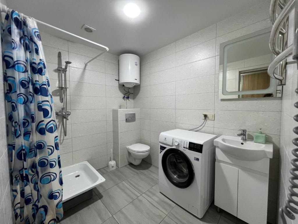 a bathroom with a washing machine and a sink at Central Park Apartment on Sumskaya in Kharkiv