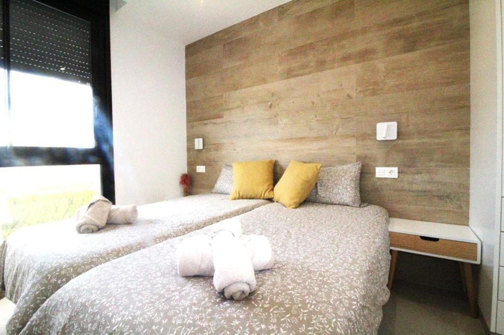 - une chambre avec 2 lits avec un ours en peluche sur le lit dans l'établissement Cactus Apartment La Ribera, à Santiago de la Ribera