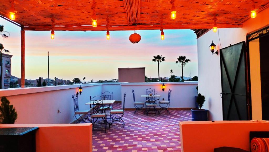 a patio with tables and chairs on a roof at VILLA YOUSRA in Marrakech