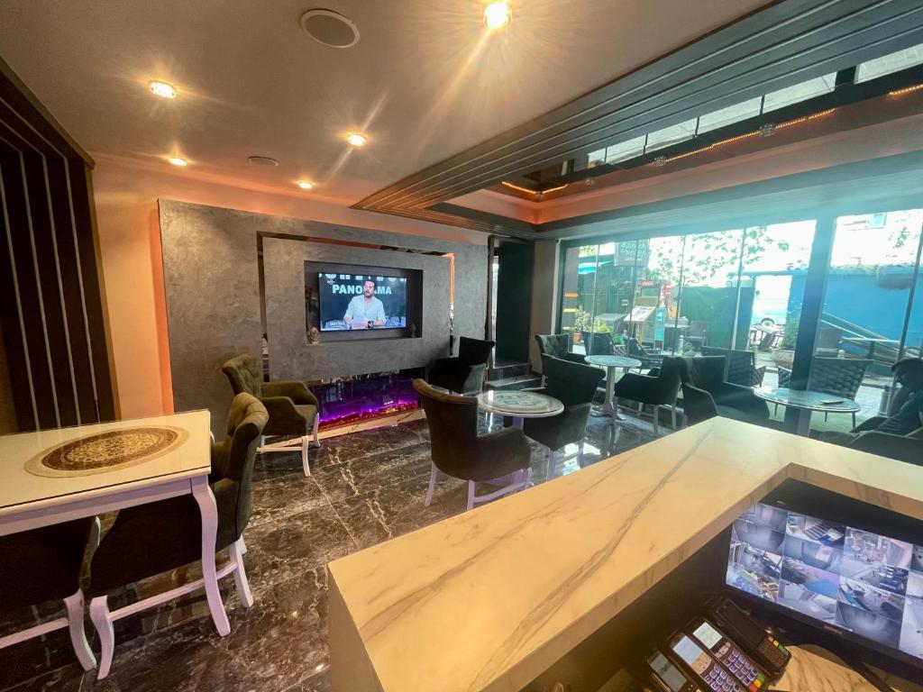 een kamer met een bar met stoelen en een televisie bij Grand Hurriyet Hotel in Istanbul
