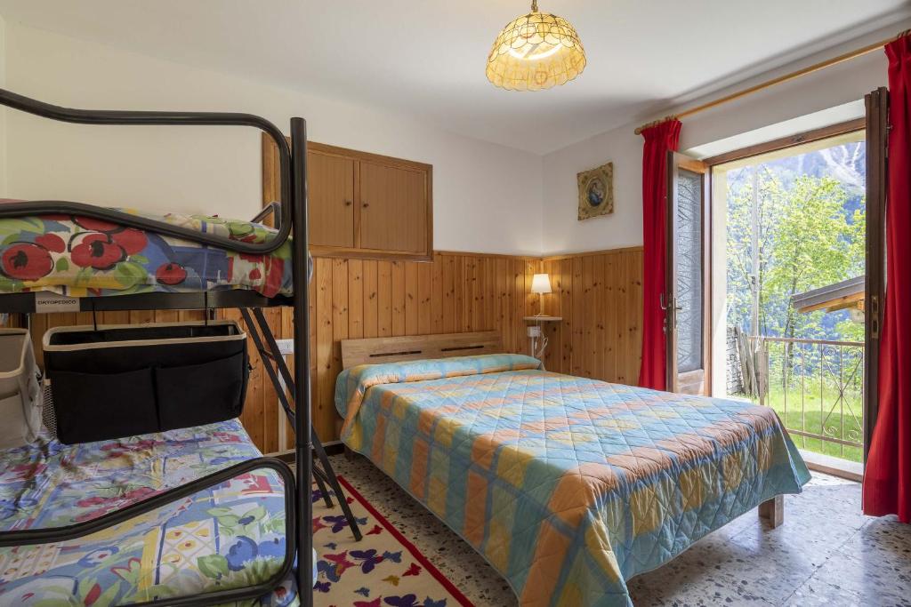 Trasquera的住宿－Il Melo，一间卧室设有两张双层床和一扇窗户。