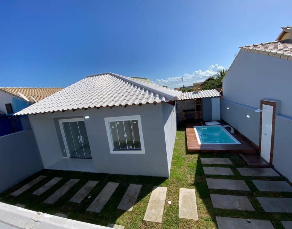a small house with a swimming pool in the yard at Casa Unamar Cabo Frio-RJ in Cabo Frio