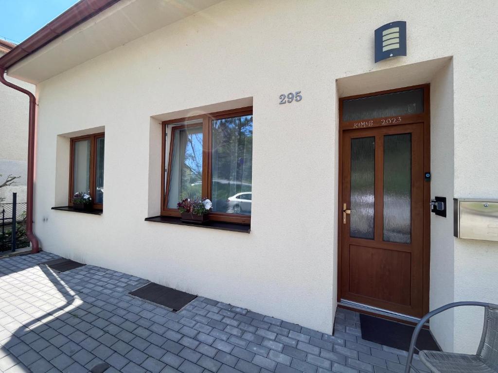 ein Haus mit einer Holztür und Fenstern darauf in der Unterkunft Apartmán na výsluní in Luhačovice