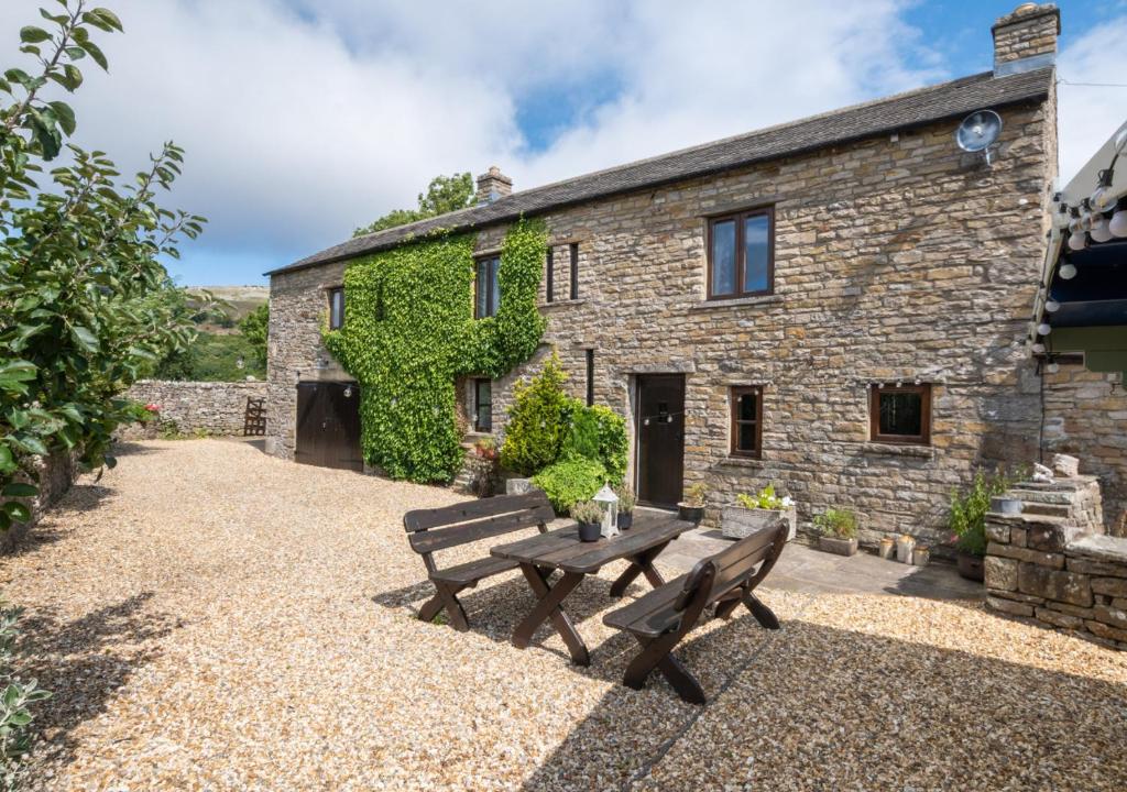 a stone house with a bench in front of it at Ballowfield Barn in Carperby