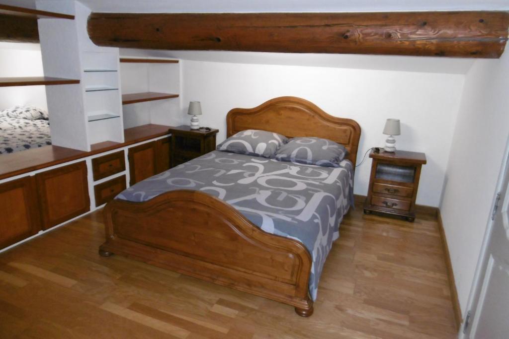 um quarto com uma cama de madeira e pisos de madeira em Chambre d'hôtes + piscine em Cavaillon