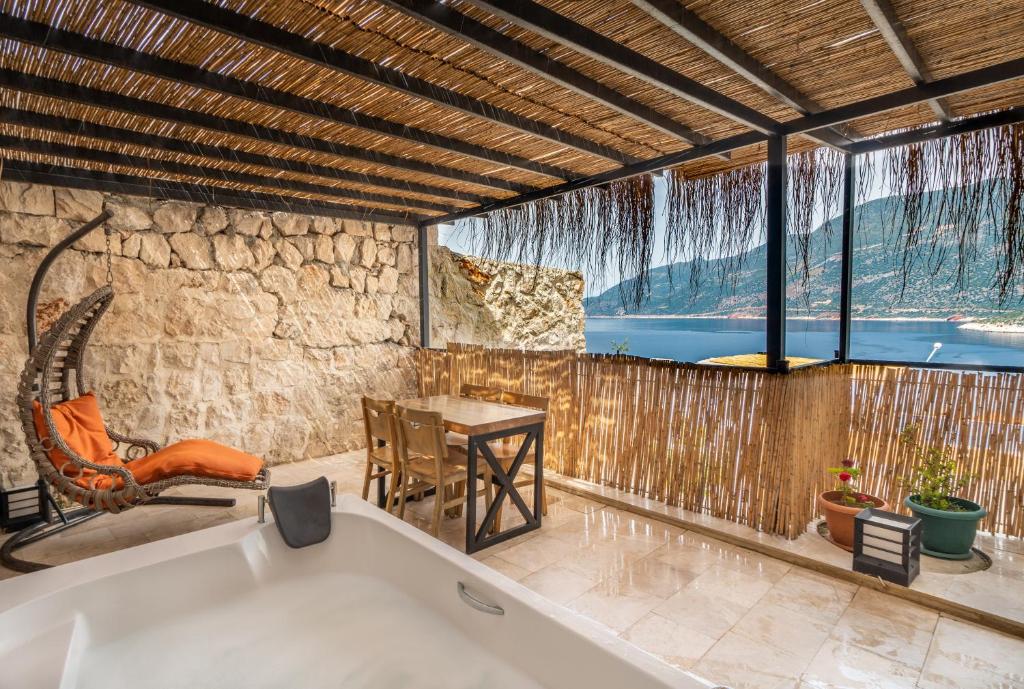 a bath tub in a room with a table and a table at Gümüş Yazar Hotel in Kaş