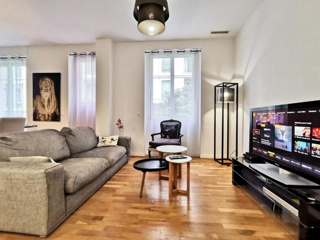 un salon avec un canapé et une télévision à écran plat dans l'établissement Appartement 'EMILIA', à Nice