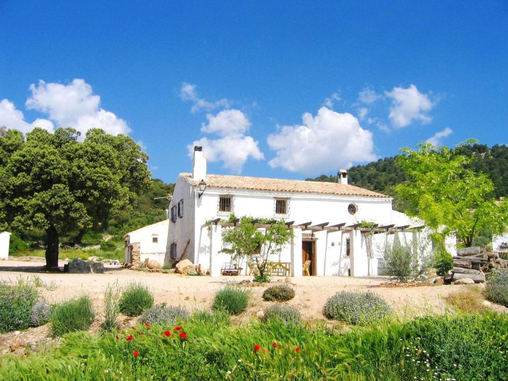 a white house with a garden in front of it at Casas Rurales Cortijo Cerro Fuentes Nuevas in Castril