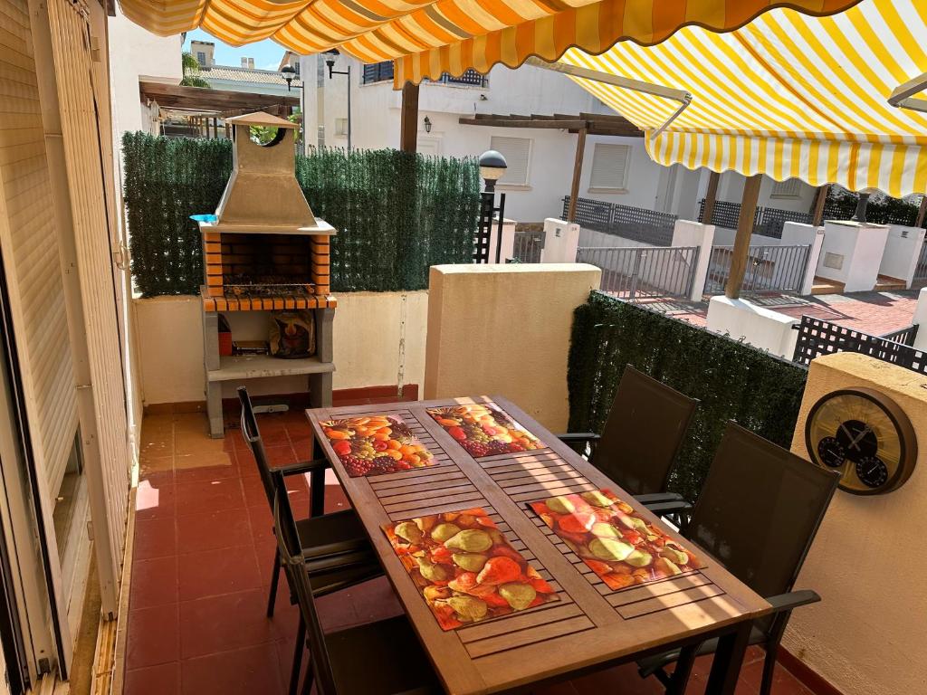 una mesa y sillas con comida en el patio en Casa adosada con piscina y dos terrazas en Alcossebre