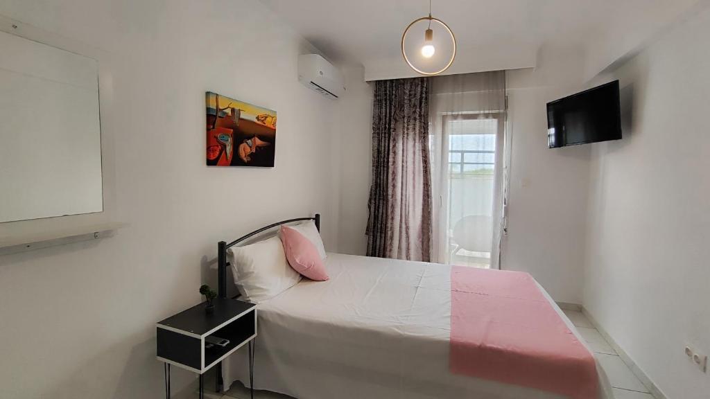1 dormitorio con 1 cama con almohada rosa en First line apartment, en Flogita