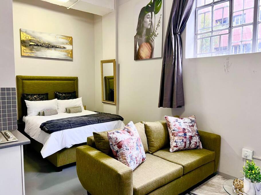 sala de estar con sofá y cama en Matcha themed Apartment in City, en Johannesburgo