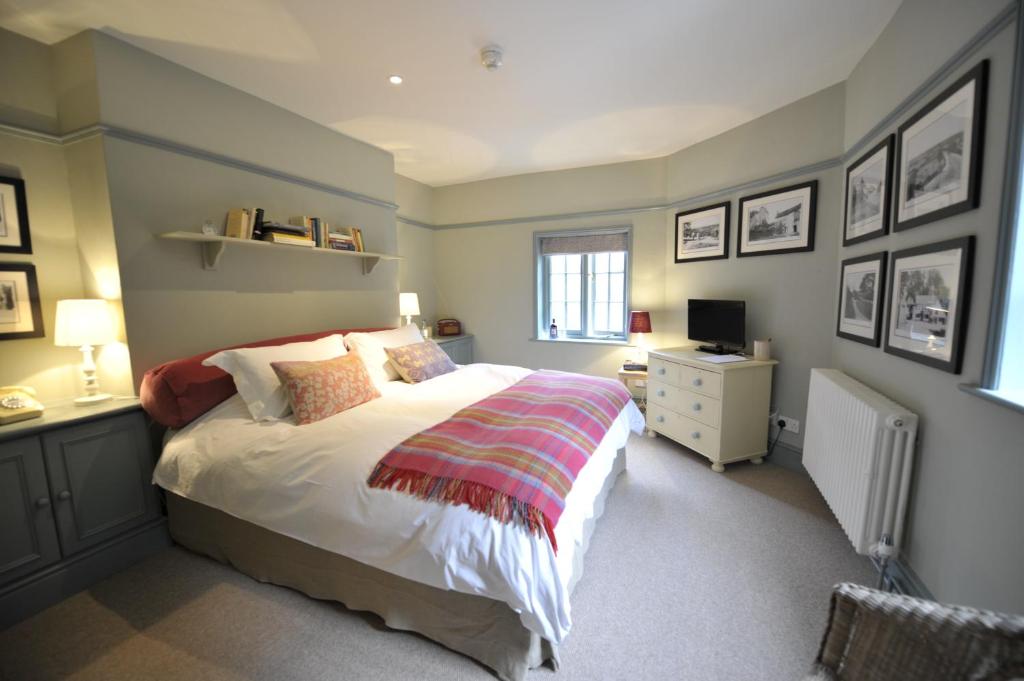 a bedroom with a bed and a desk with a television at Bel And The Dragon-Churt in Farnham