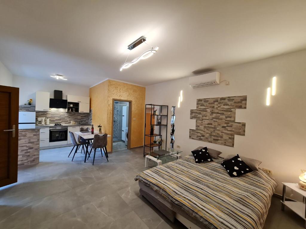 a bedroom with a large bed and a kitchen at Studio Apartman D&D in Brseč