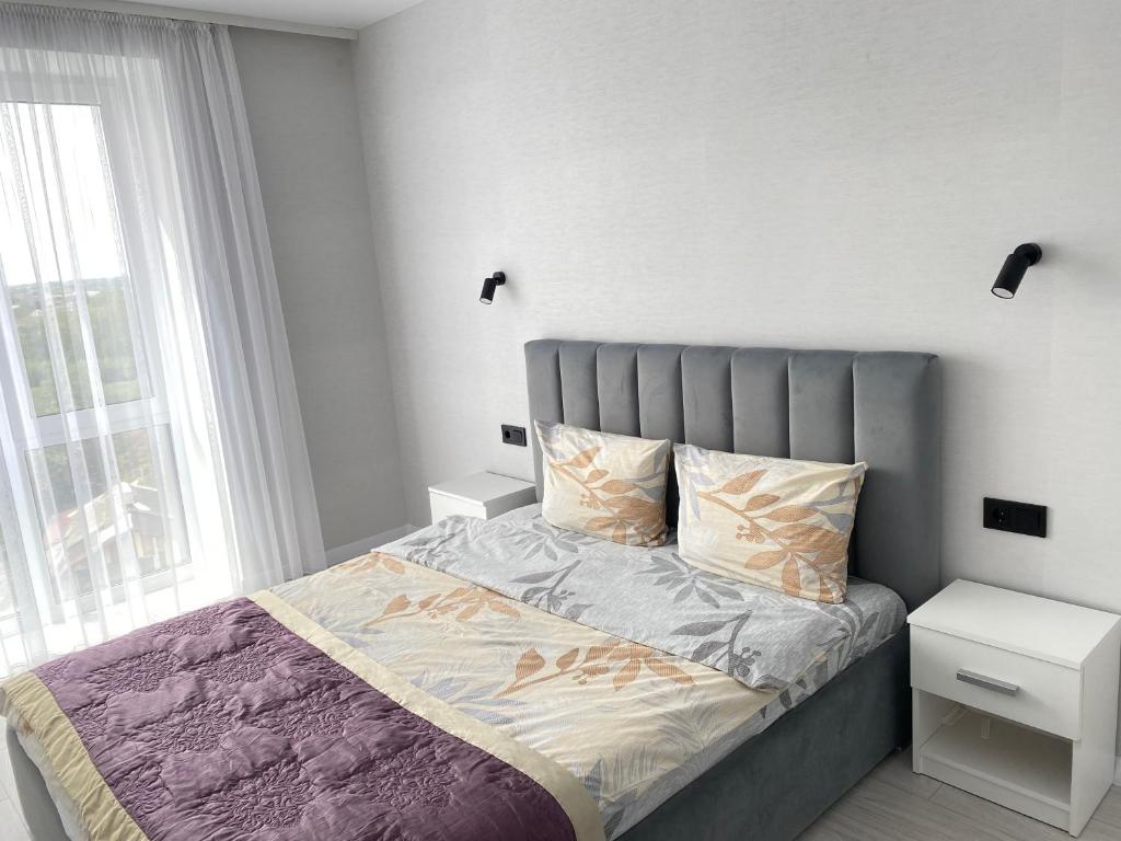 1 dormitorio con cama y ventana grande en Люкс для вибагливих в центрі en Lutsʼk