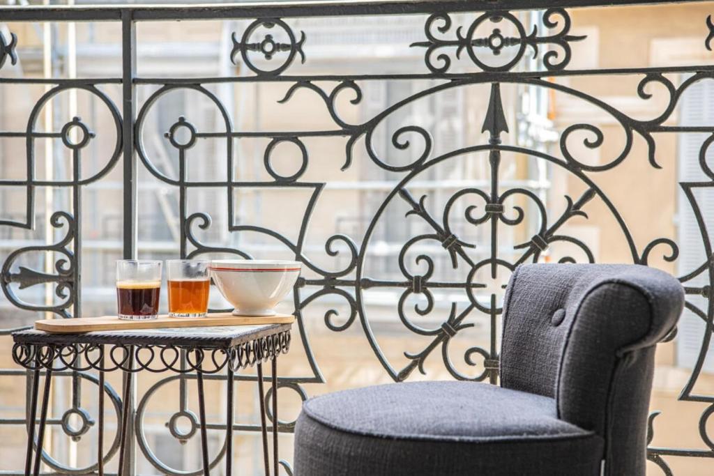 une table avec deux verres de bière et une chaise sur un balcon dans l'établissement Grand 2 chambres avec balcon Parc Longchamp, à Marseille