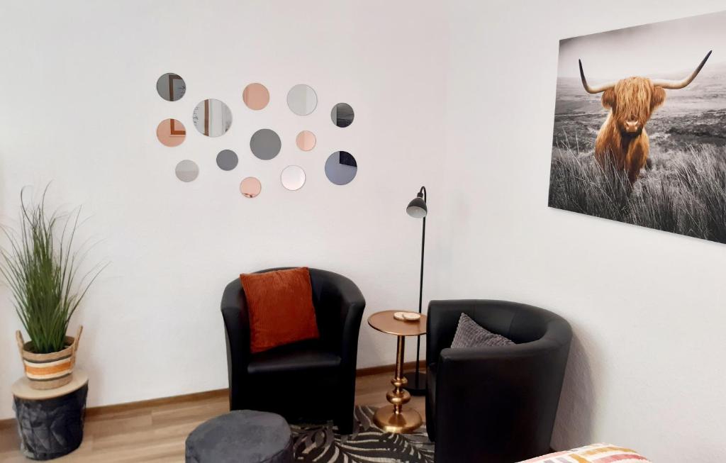 ein Zimmer mit zwei Stühlen und einem Bild eines Stiers an der Wand in der Unterkunft FeWo Greiwe in Telgte
