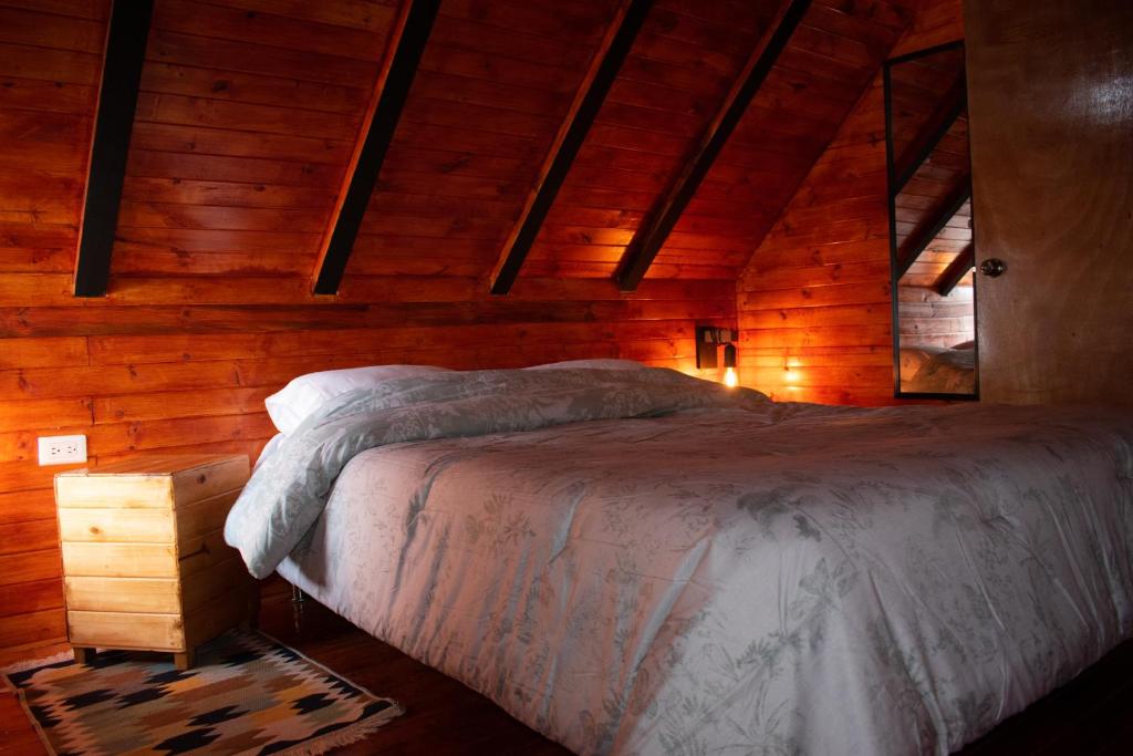 - une chambre avec un lit dans une cabane en bois dans l'établissement Club AVIVA Guatavita - Hostel - Restaurante, Disco & Bar, à Guatavita