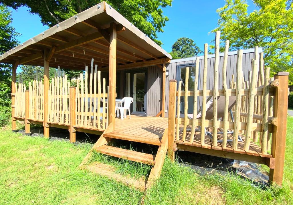 une cabine avec une terrasse en bois dans l'herbe dans l'établissement Dôme Paradise by Home From Home, à Dol-de-Bretagne